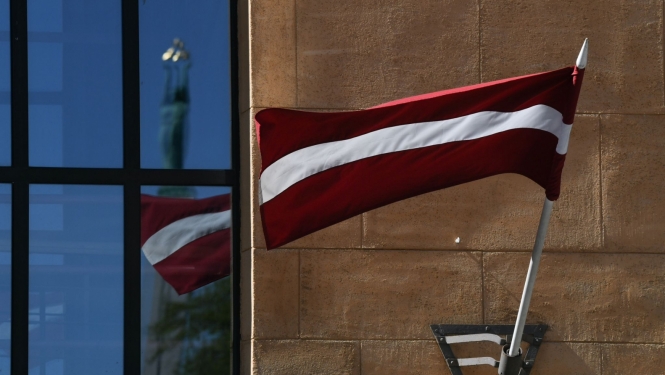 Latvijas karogs, loga atspīdumā Brīvības piemineklis