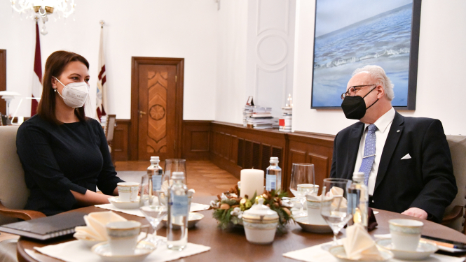 Anita Muižniece un Egils Levits sēž pie galda un sarunājas