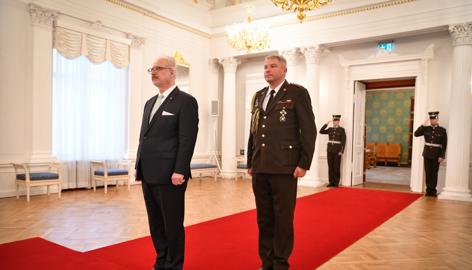 Egils Levits un militārais adjutants stāv Rīgas pils Baltajā zālē