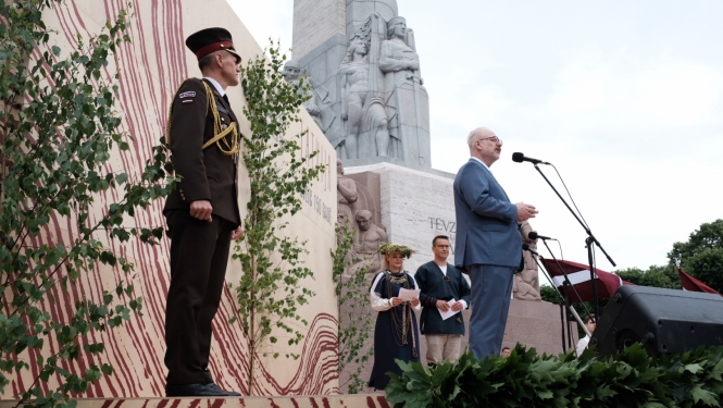 Valsts prezidents Egils Levits uz skatuves pie Brīvības pieminekļa uzrunā gājiena dalībniekus