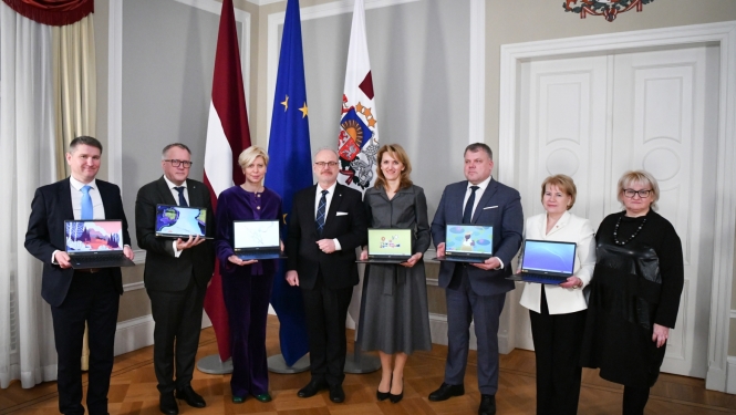 Padomes dalībnieki kopbildē ar Valsts prezidentu Egilu Levitu, daži tur atvērtus klēpjdatorus