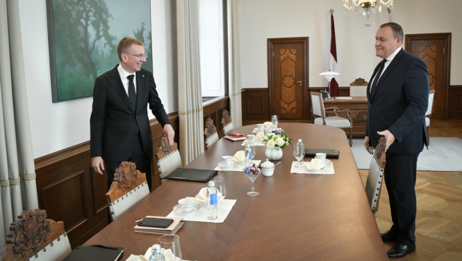 Valsts prezidents un iekšlietu ministrs sēžas pie galda