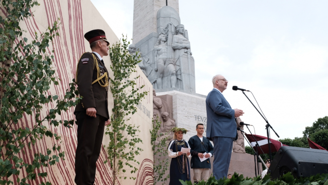 Valsts prezidents Egils Levits uz skatuves pie Brīvības pieminekļa uzrunā gājiena dalībniekus