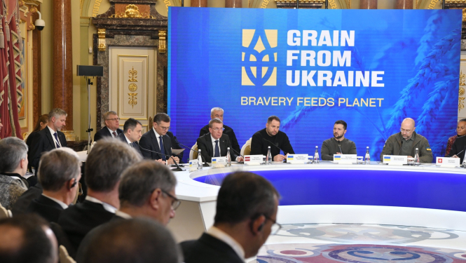 samita dalībnieki sēž pie galda