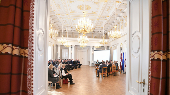 Skats caur atvērtām durvīm uz sarunas dalībniekiem zālē