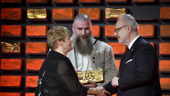 Egils Levits spiež roku Maijai Ukstiņai, Edgars Bergs stāv ar balvu rokās