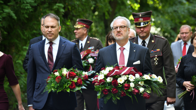 Gustava Zemgala mazmazdēls Mārtiņš Andersons un Egils Levits nes ziedus
