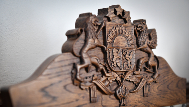 Latvijas valsts ģerboņa atveidojums koka krēsla atzveltnē