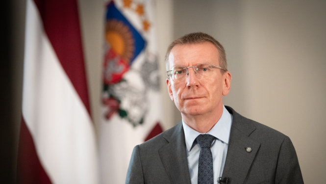 Valsts prezidents Edgars Rinkēvičs Rīgas pils Ģerboņu zālē - fonā Latvijas karogs un Valsts prezidenta standarts. 