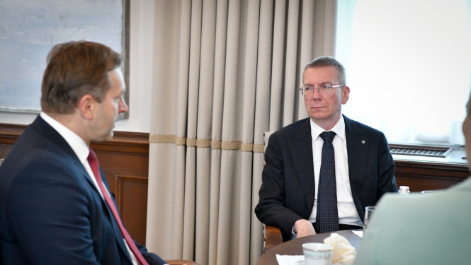 Aldis Laviņš un Edgars Rinkēvičs sēž pie galda un sarunājas