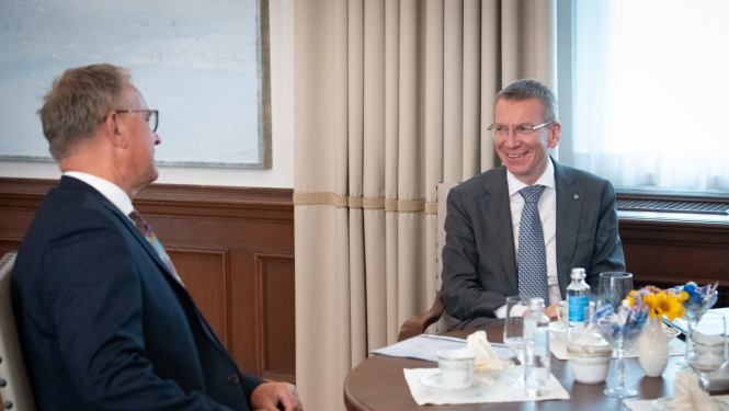 Nauris Puntulis un Edgars Rinkēvičs sēž pie galda un sarunājas