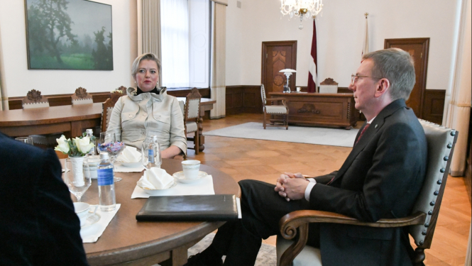 Kristīne Saulīte un Edgars Rinkēvičs sēž pie apaļa galda un sarunājas