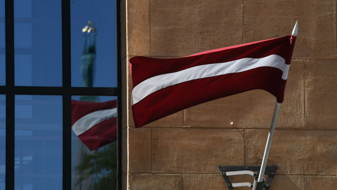 Latvijas karogs, loga atspīdumā Brīvības piemineklis