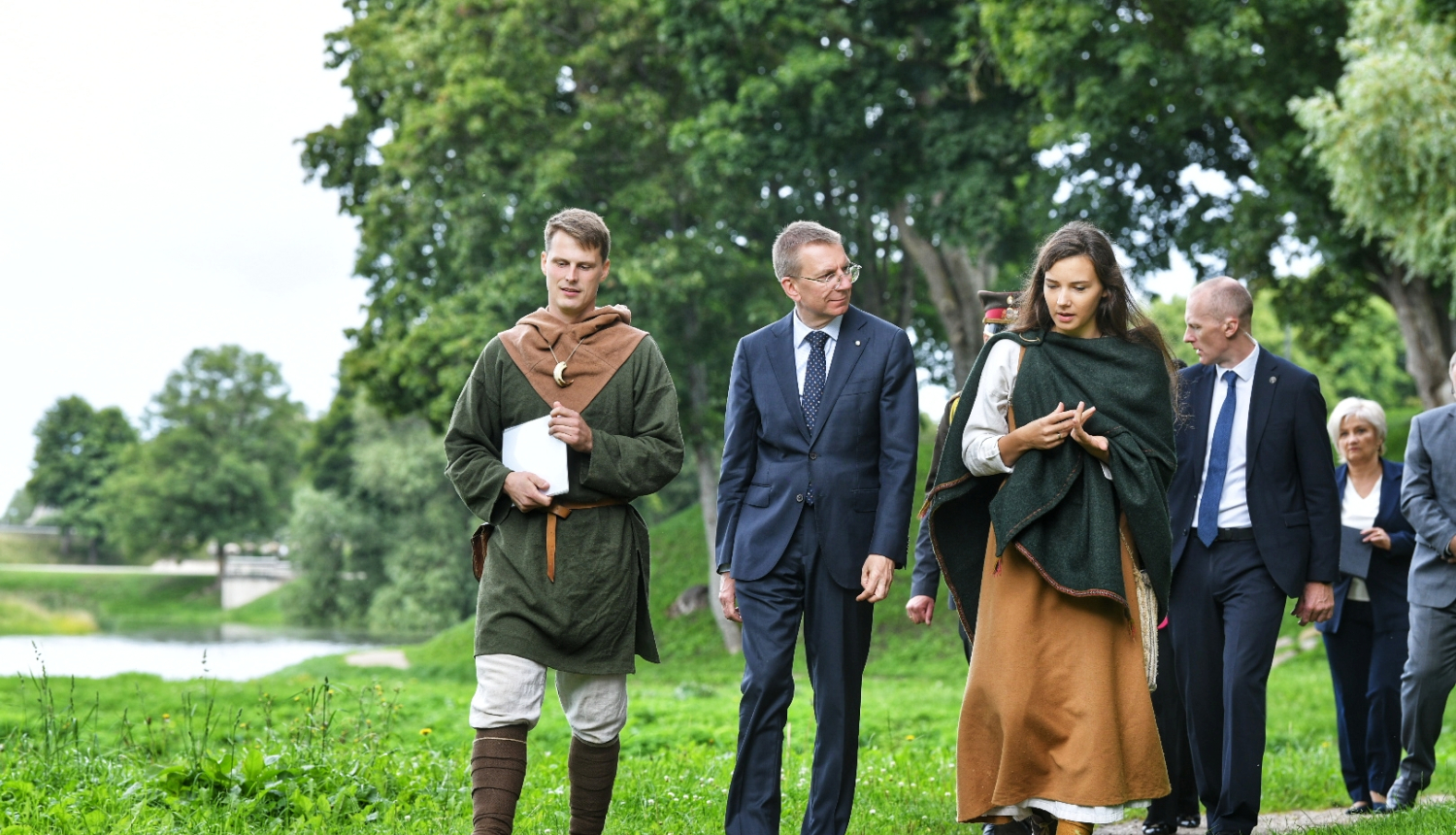 Valsts prezidents pastaigājas pa Grobiņas viduslaiku pils parku kopā ar pils darbiniekiem, kuri ģērbti vēsturiskos tērpos