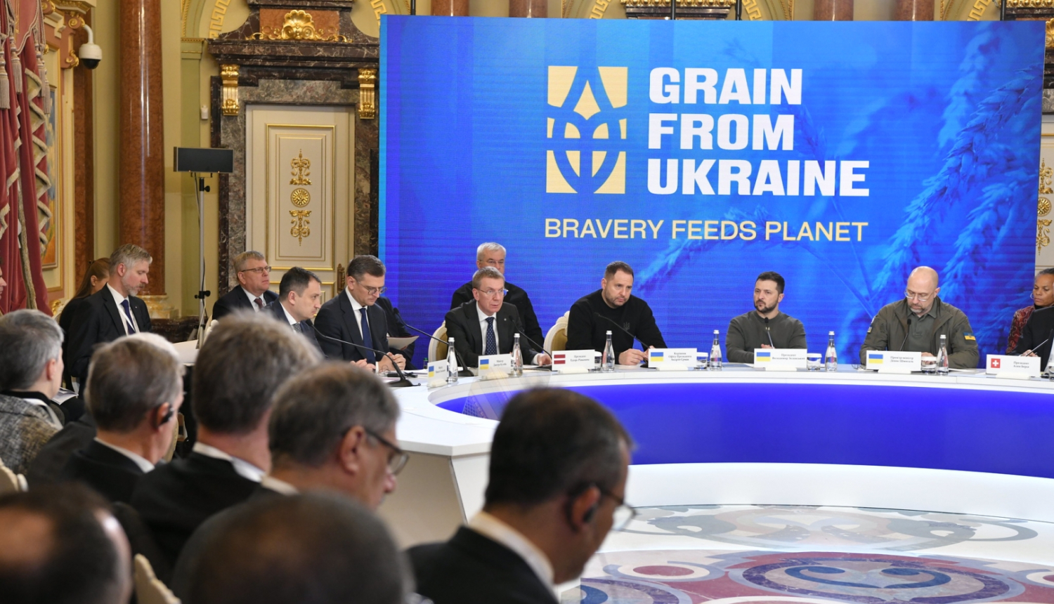 samita dalībnieki sēž pie galda