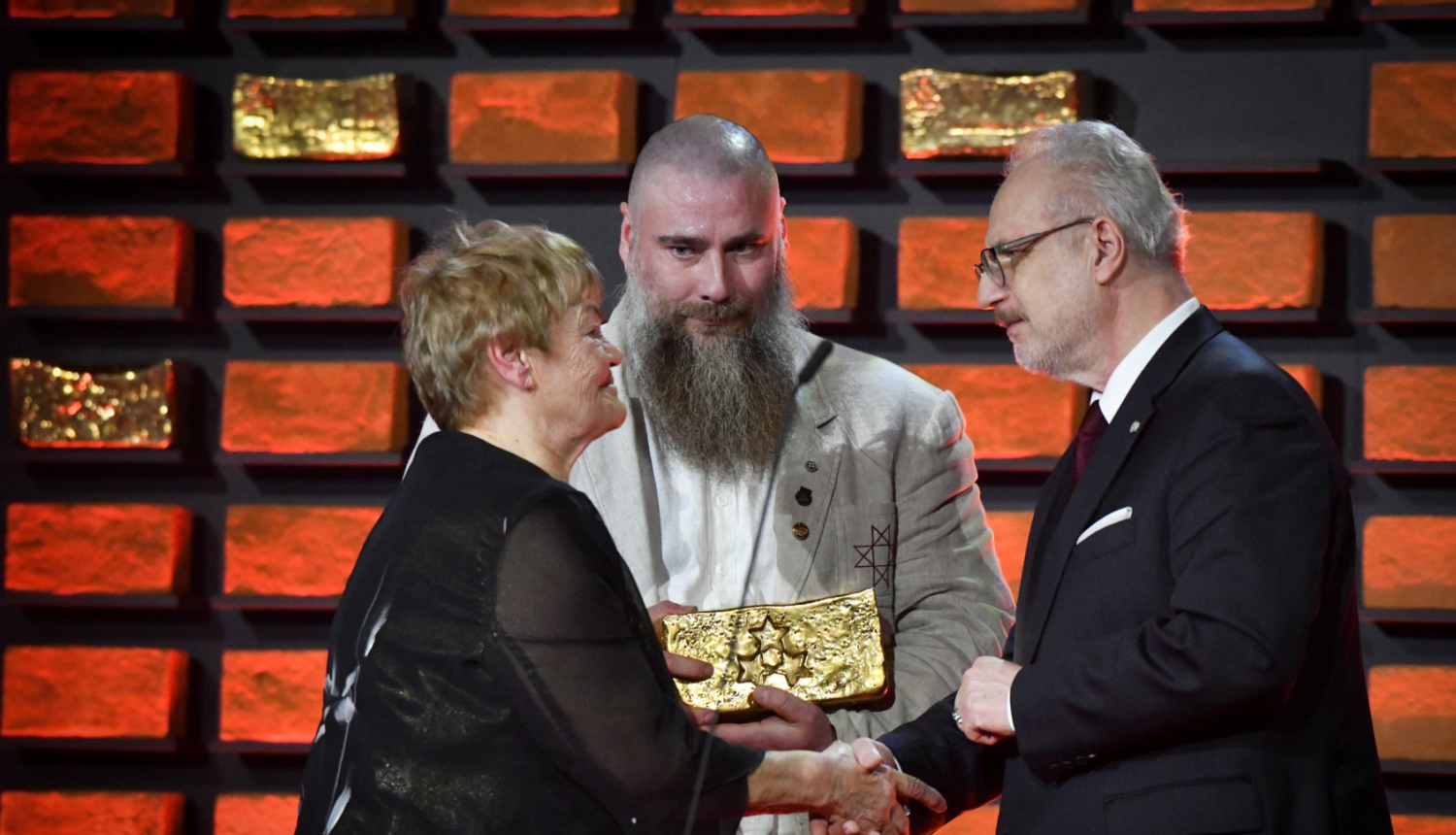 Egils Levits spiež roku Maijai Ukstiņai, Edgars Bergs stāv ar balvu rokās