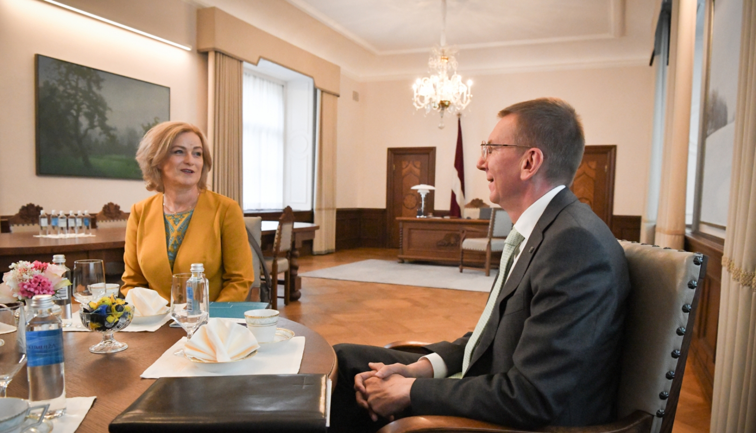 Ilze Indriksone un Edgars Rinkēvičs sēž pie galda un sarunājas