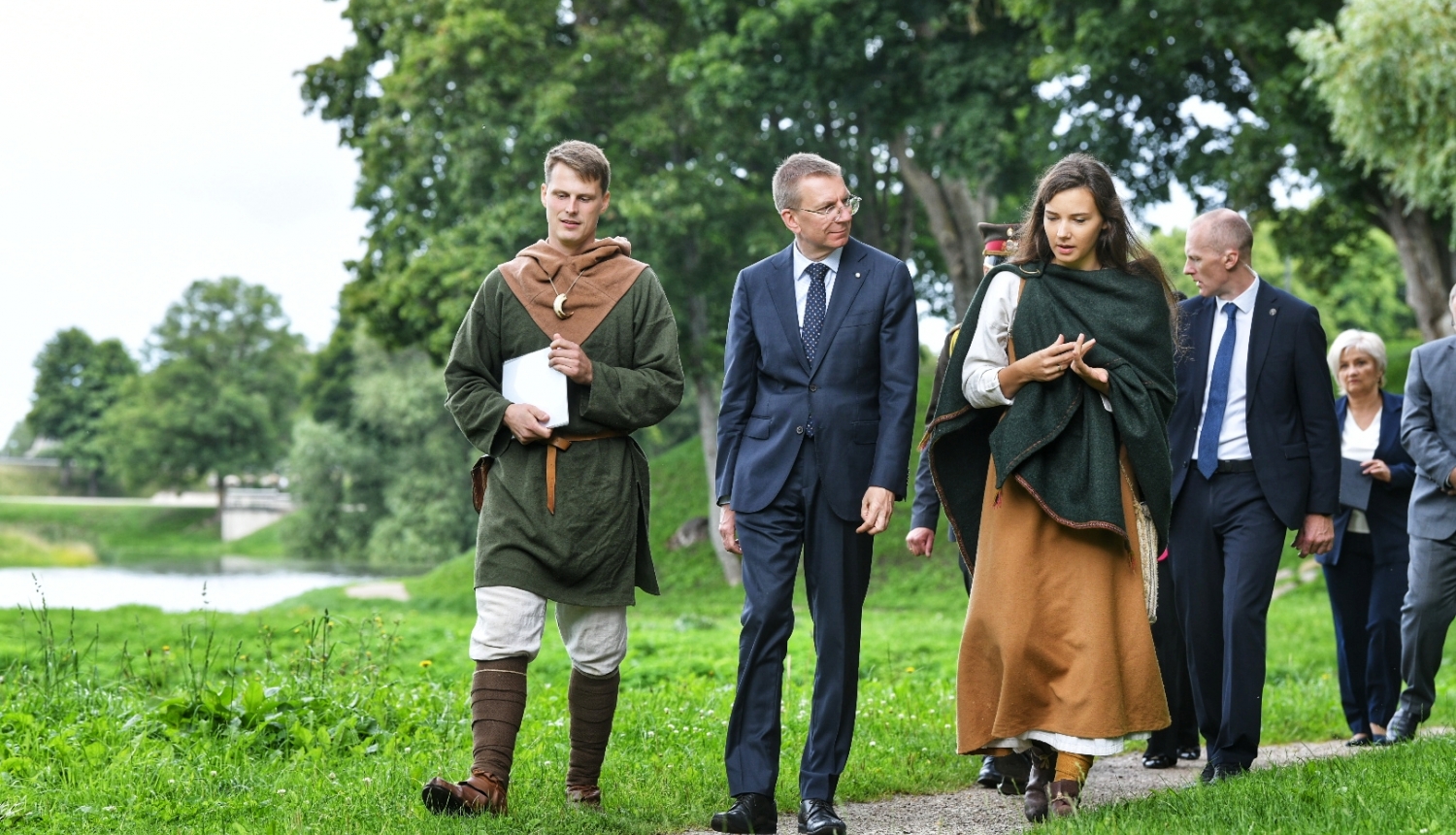 Valsts prezidents pastaigājas pa Grobiņas viduslaiku pils parku kopā ar pils darbiniekiem, kuri ģērbti vēsturiskos tērpos