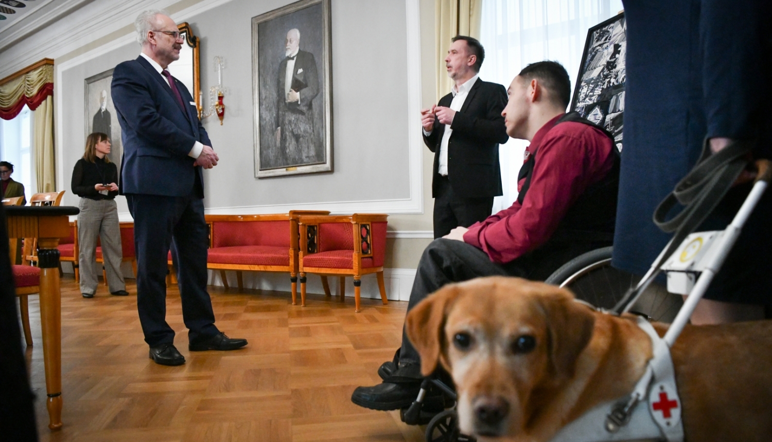 Egils Levits sarunājas ar viesiem, foto priekšplānā suns - asistents