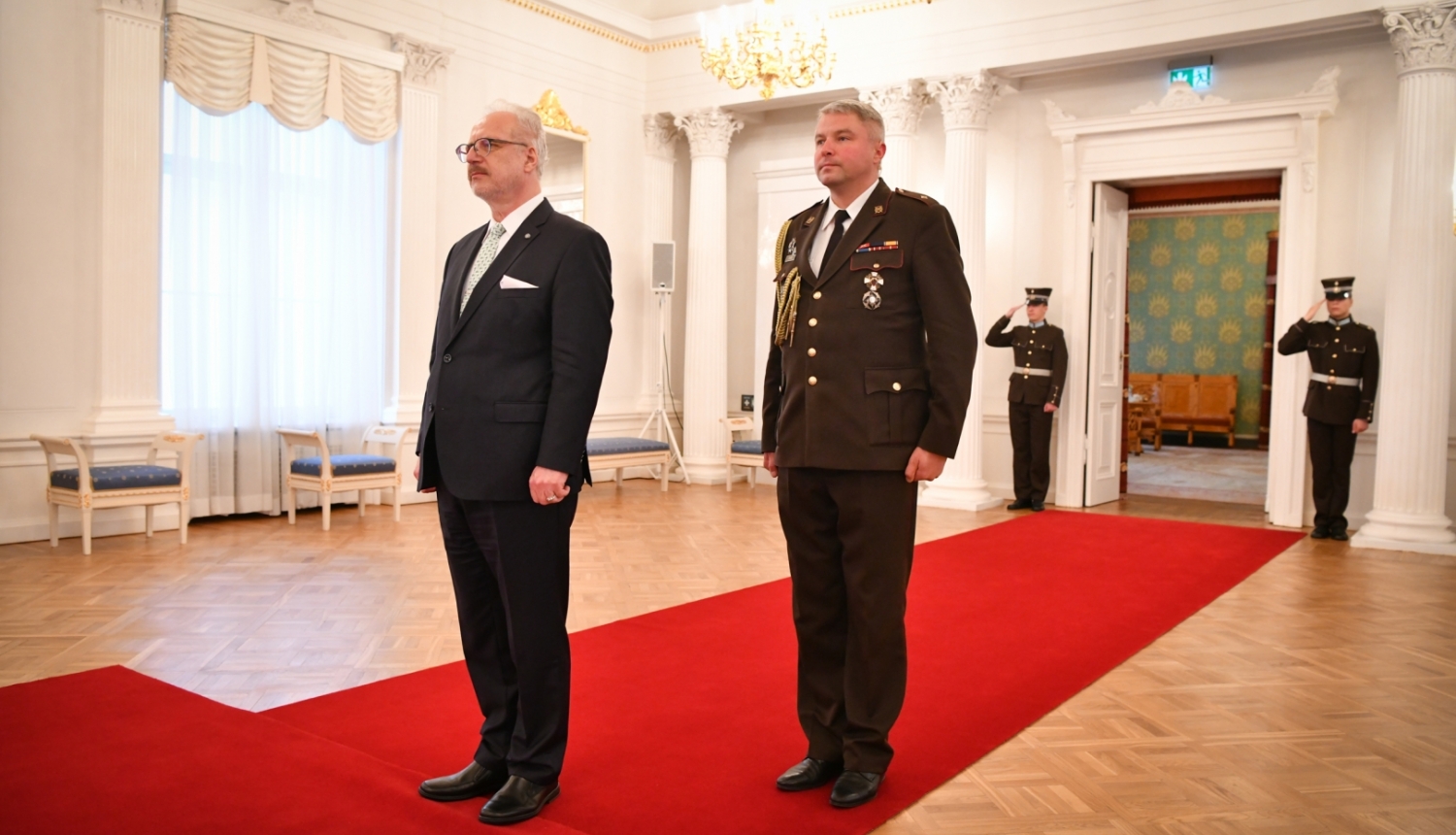 Egils Levits un militārais adjutants stāv Rīgas pils Baltajā zālē