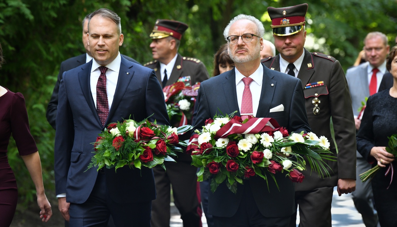 Gustava Zemgala mazmazdēls Mārtiņš Andersons un Egils Levits nes ziedus