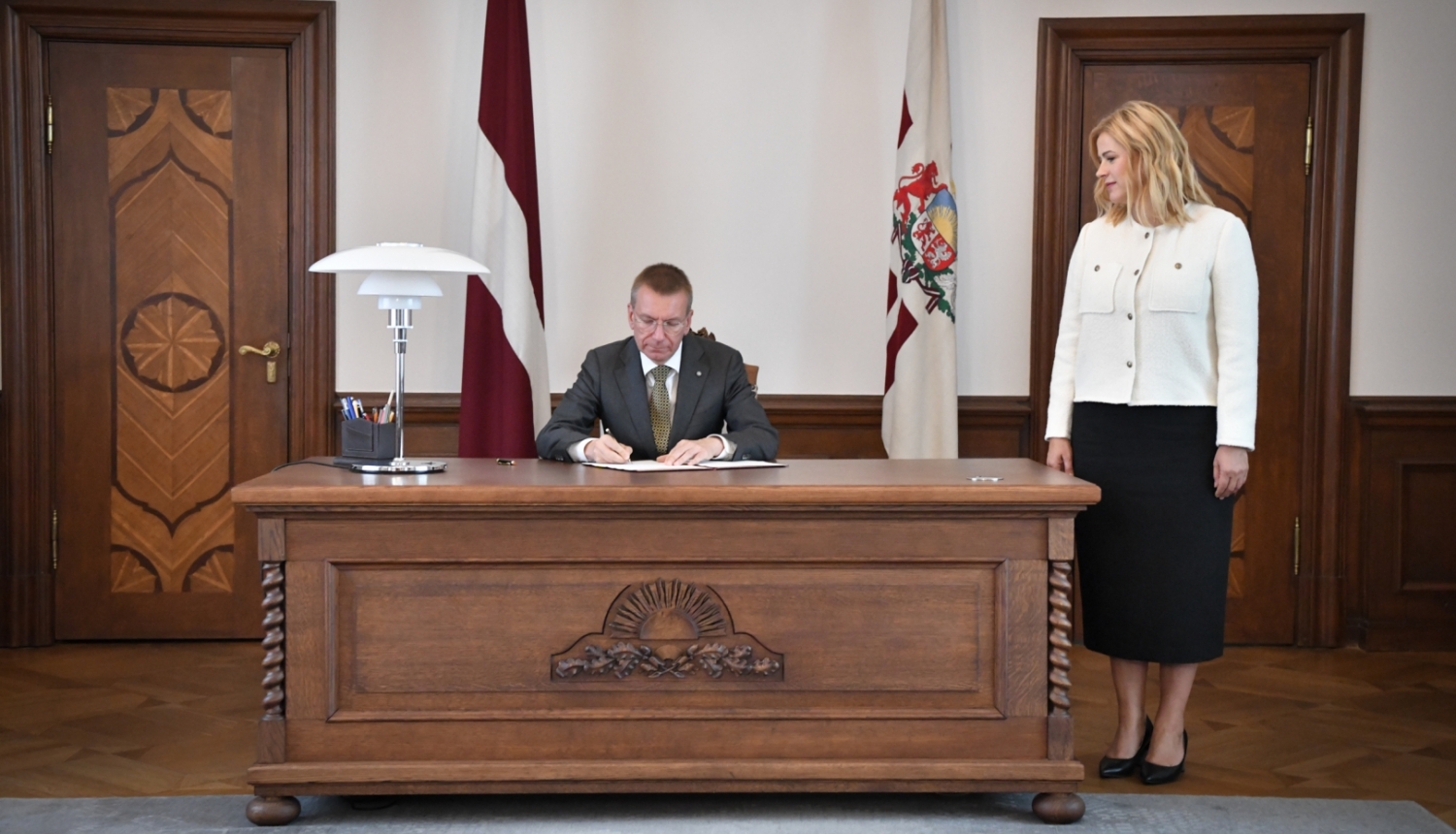 24.08.2023. Valsts prezidents Edgars Rinkēvičs paraksta rīkojumu, kurā aicina Eviku Siliņu sastādīt Ministru kabinetu. Pie galda pa labi stāv Evika Siliņa.